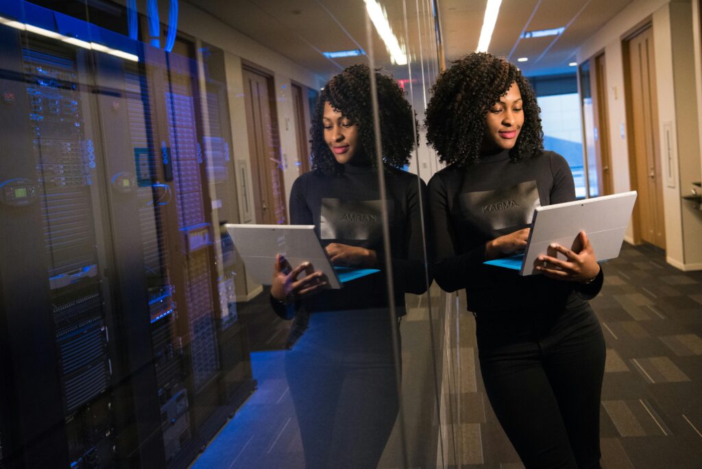 A girl standing in a web development company with a laptop